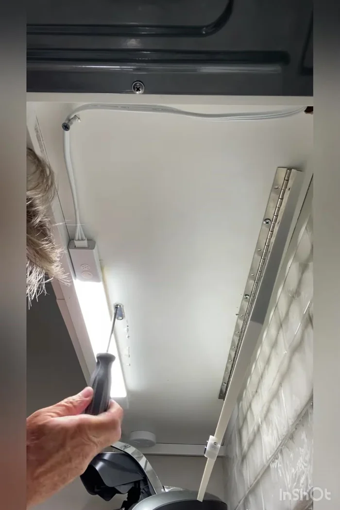 Insert and tighten the small wood screws to secure the metal plate to the cabinet, ensuring flush insertion for maximum magnet contact.