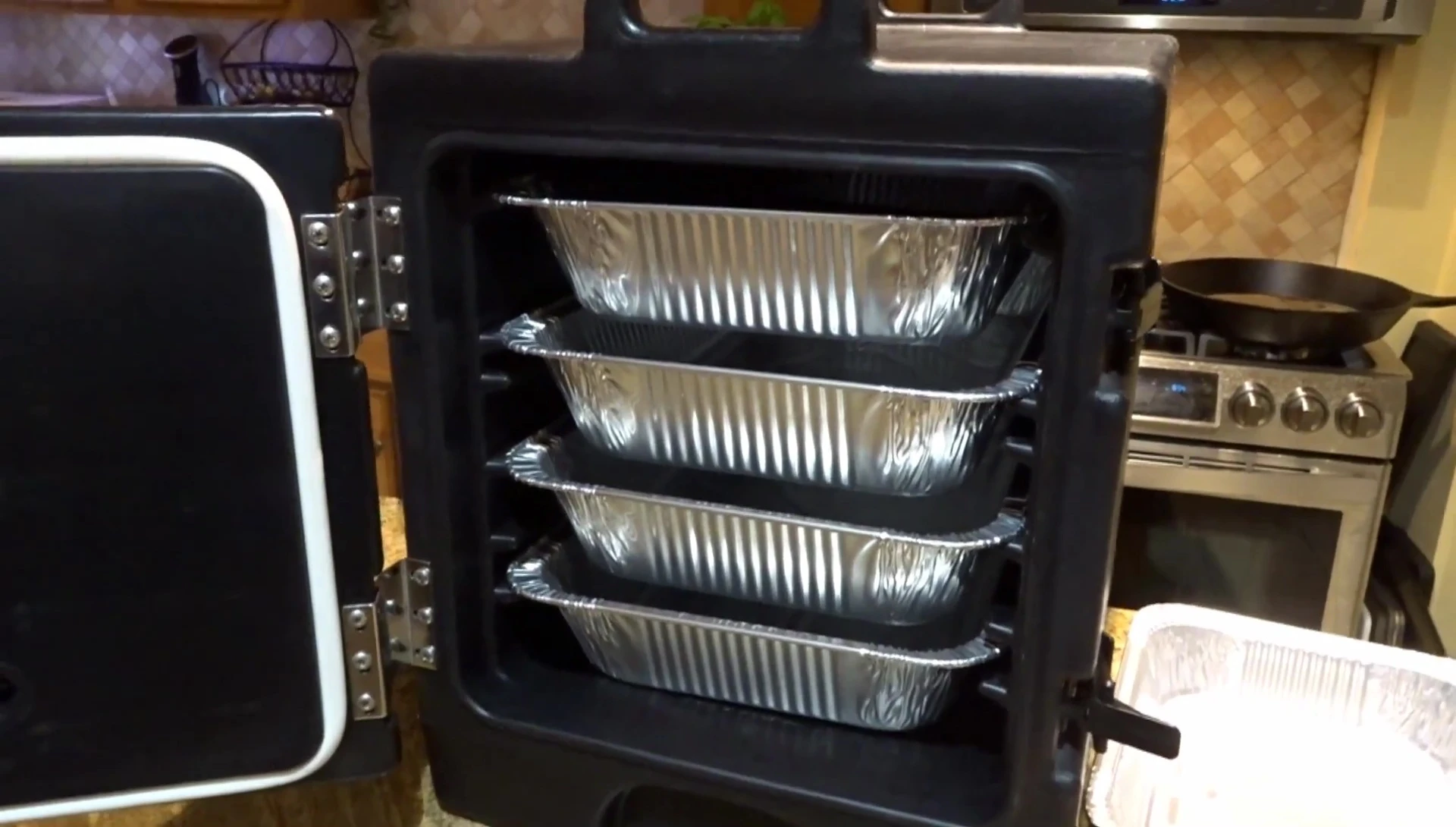 The smaller Cambro filled with four full-size catering pans.