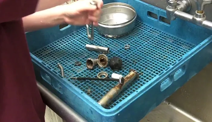 Align the spray hose with the clutch nozzle, squeeze lightly, and flush out the residue until the water runs clear.