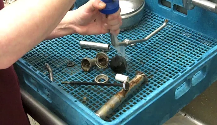 Align the spray hose with the clutch nozzle, squeeze lightly, and flush out the residue until the water runs clear.