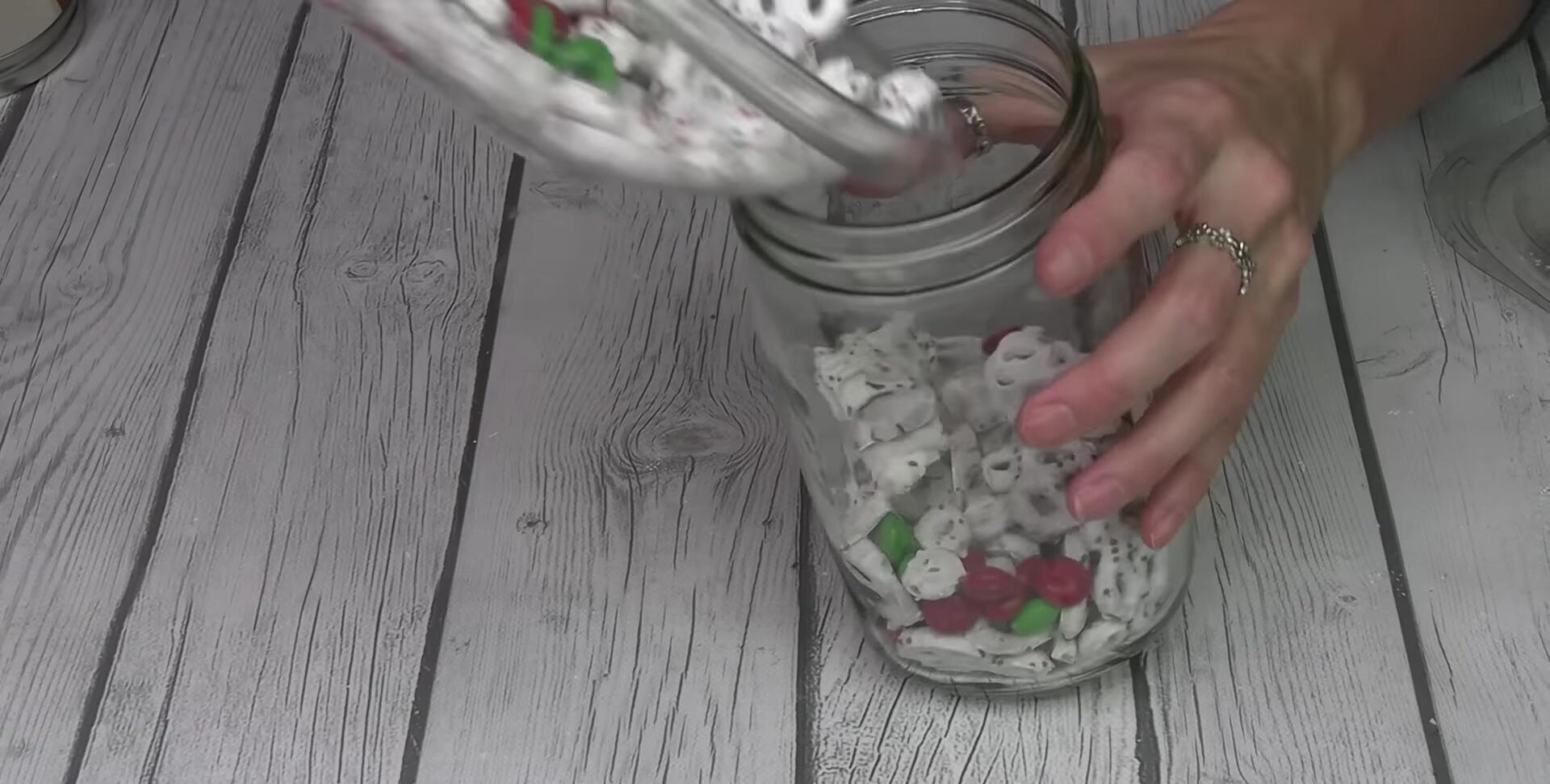Large mason jar filled with layered Santa snack mix