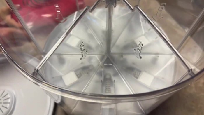 The dispenser includes a measuring cup on the side for portion control.