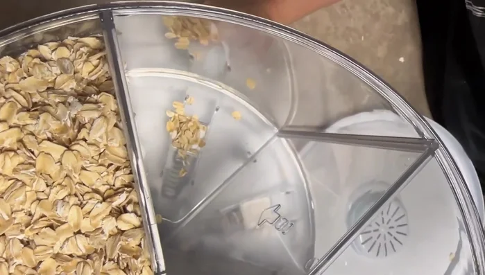 If the grain gets stuck at the bottom, use your finger to push it towards the dispensing mechanism.