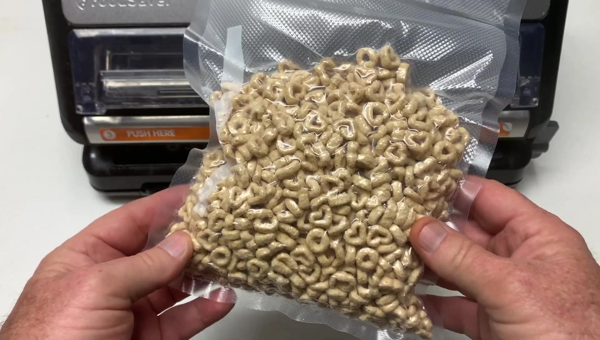 The reviewer holding up the sealed bag, emphasizing the value.