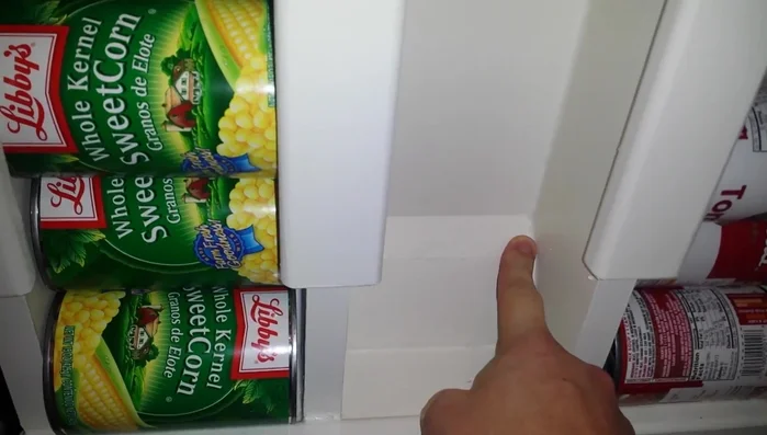 Add a kicker (angled piece of MDF with baseboard) at the bottom to tilt cans towards the front for easy access.