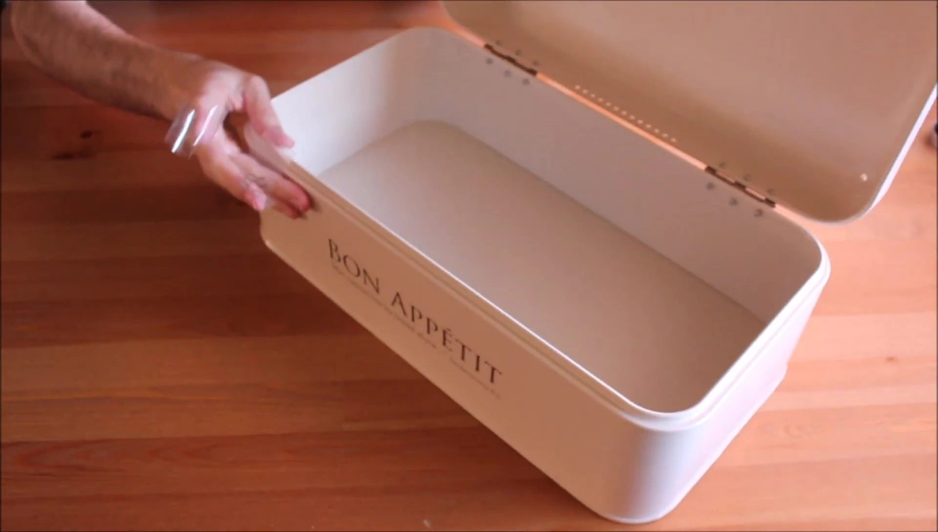 The reviewer holding the bread box and expressing their positive first impression.