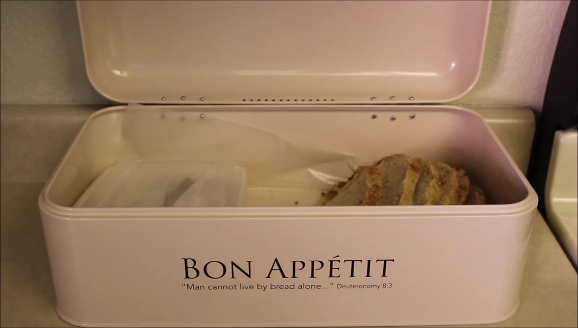 The reviewer showing the bread inside the bread box to illustrate freshness.