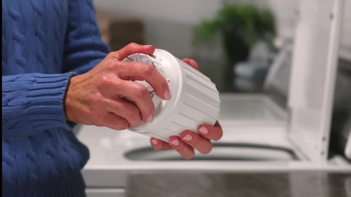 Separate the lower part of the dispenser by squeezing the bottom of the housing and pulling on the cup at a slight angle.