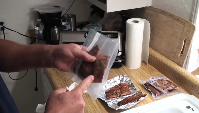 Wipe off any oil from the fish on the bag's edge with a paper towel to ensure a better seal.