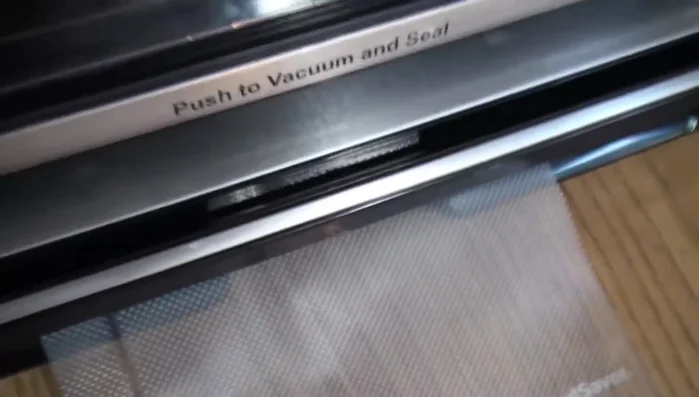 Close the FoodSaver and seal the bag. The red light indicates when sealing is complete.