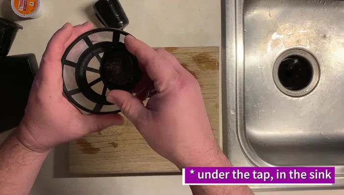 Rinse the used K-Cup under the sink to remove loose coffee grounds.