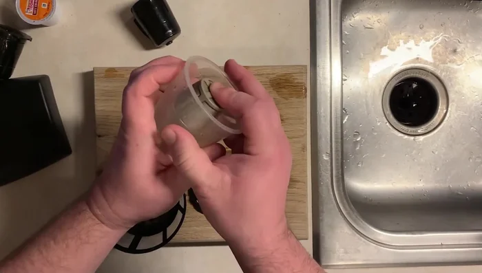 Place the mesh strainer in the sink to catch any remaining grounds that might be released during washing.