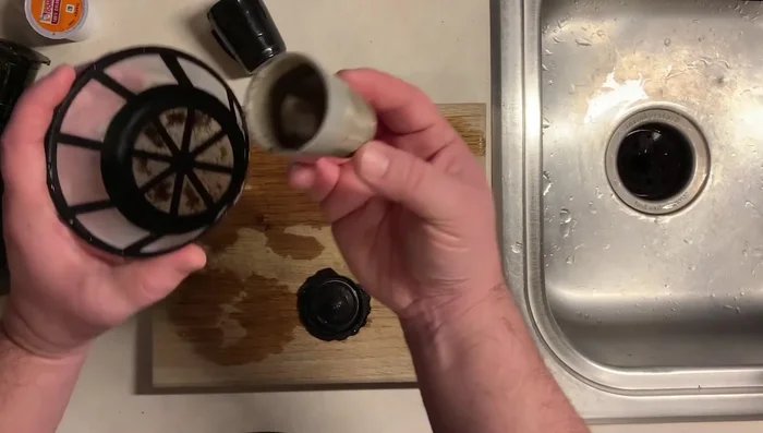 Place the mesh strainer in the sink to catch any remaining grounds that might be released during washing.