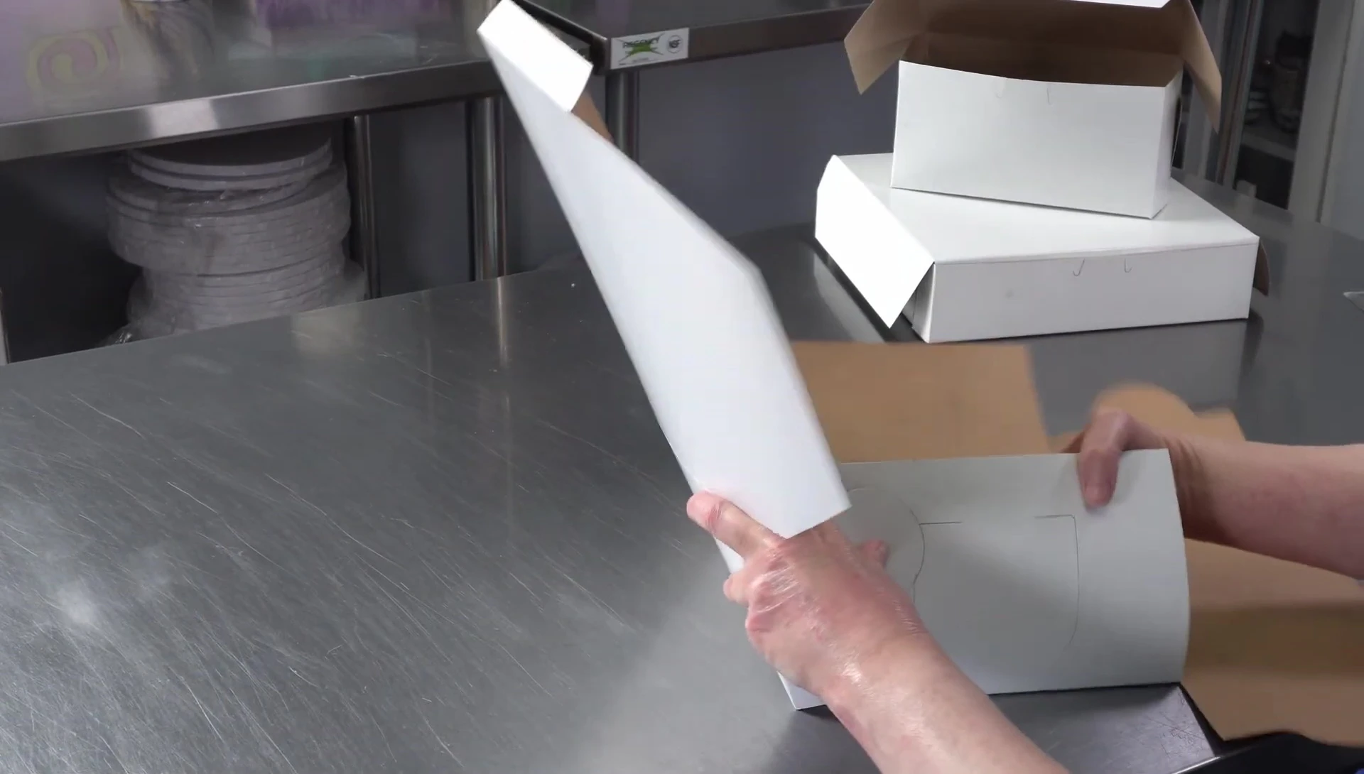 Demonstrating how to securely place a cake into an 8x8 inch box