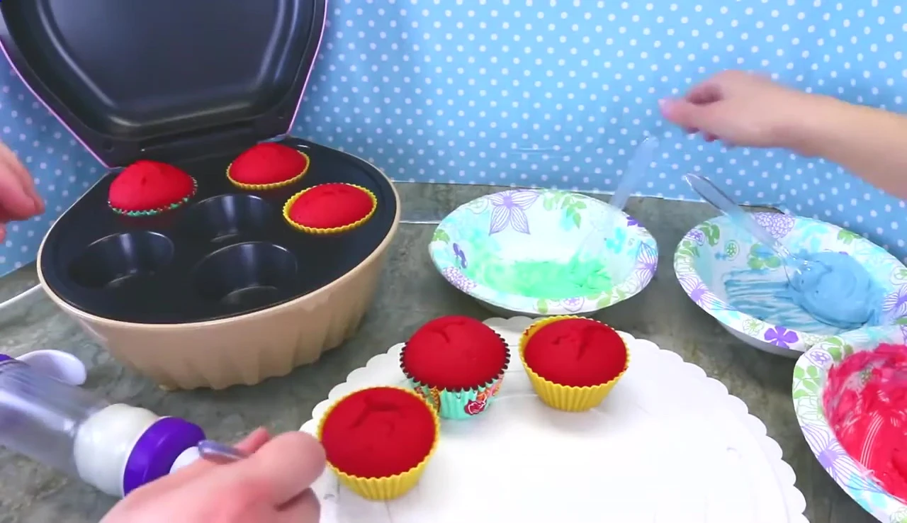 Green and red frosting being prepared.