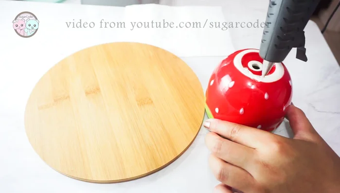 Apply hot glue to the top of the inverted strawberry pot.