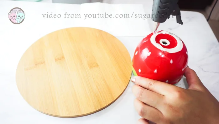 Quickly place the glued pot onto the center of the round cutting board.