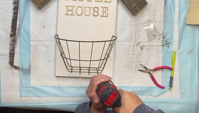 Secure the basket: Attach the wire basket to the screw eye hooks.