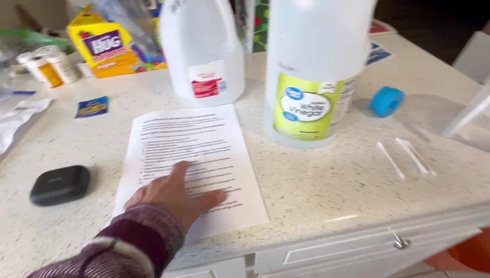 Remove the cap from a spare empty 5-gallon bottle. Pour 2 cups of white vinegar (or 2 tablespoons of bleach) and 2 gallons of hot tap water into the empty bottle.