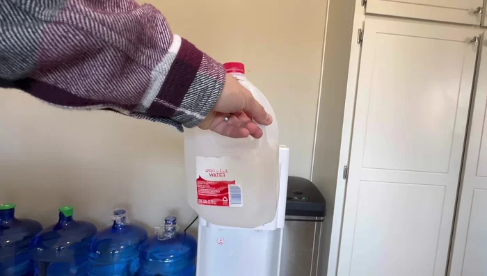 Fill the empty 5-gallon bottle with 2 gallons of hot tap water and use this to flush the system. Drain the water from the front and then the back of the dispenser.