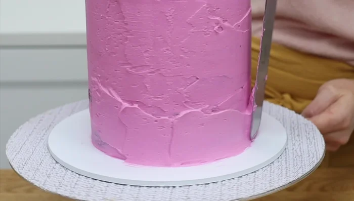 Apply the crumb coat while the cake is still frozen. The frosting will glide on smoothly.