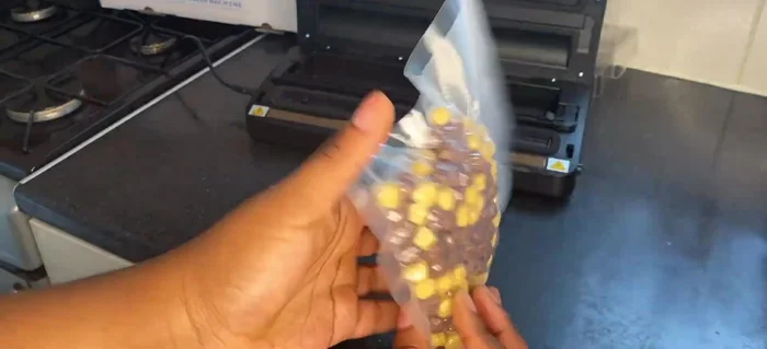 Press the buttons on the sides of the vacuum sealer to open it.