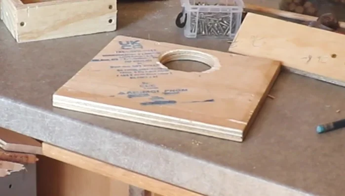 Drill a hole through the shelf, potentially using a smaller hole saw to prevent jams. Ensure the hole's placement prevents the mechanism from completely coming out.