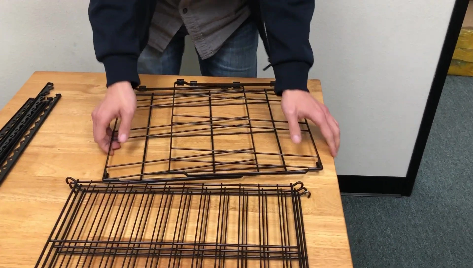 Person demonstrating how to attach the first rack to the base, starting from the bottom and pushing upwards.