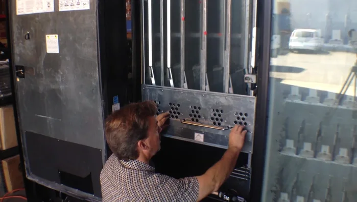 Carefully pull the rods to adjust the width to accommodate your package type. For cans, the rods go in the bottom position; for bottles, the top position. Reinsert the rods and double-check your adjustment.