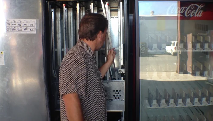 Adjust the column spacers for the correct package type (cans, bottles, etc.). For 12oz cans, set the spacers all the way to the outside. Insert the bottom spacer first into the slots, lift slightly to hook it, and then lower it completely. Repeat for the other side.