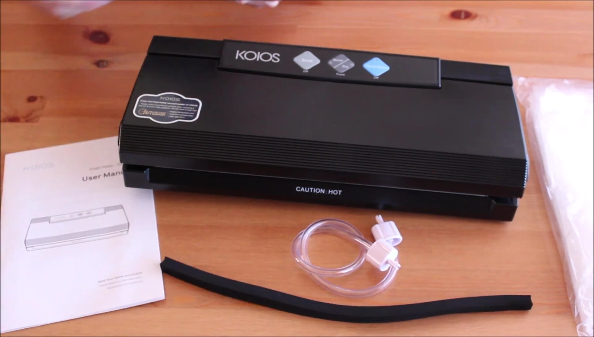 Close-up of the KOIOS vacuum sealer box being opened to reveal its contents