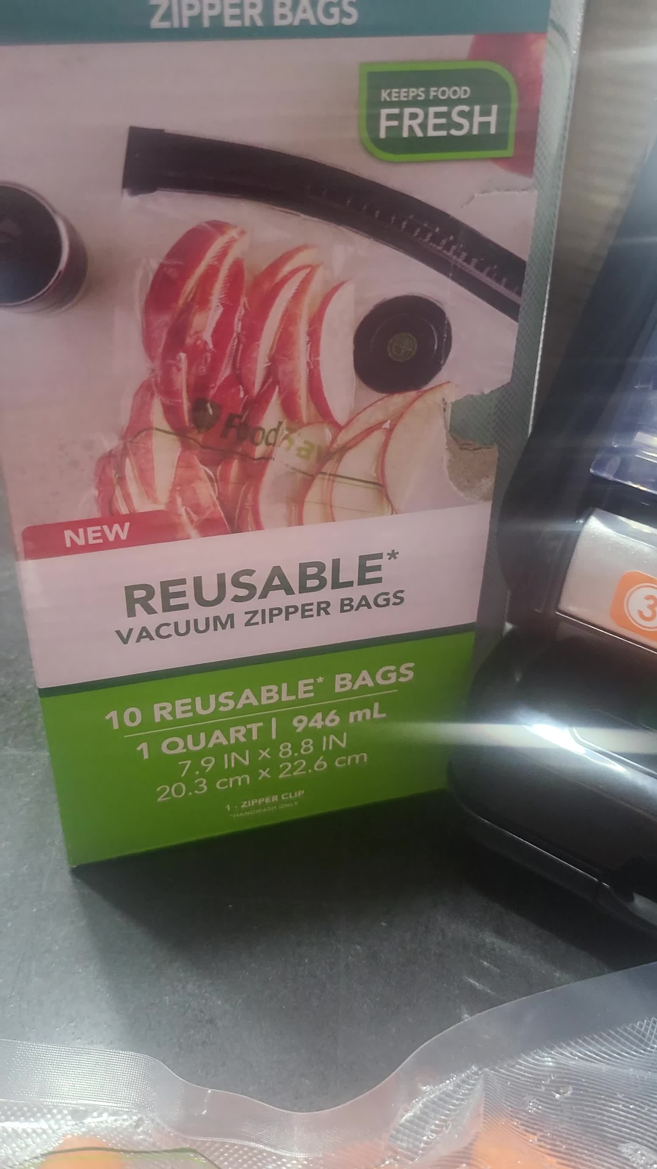 Close-up of the FoodSaver reusable vacuum zipper bag packaging and the included accessory tool.