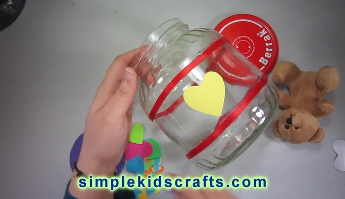 Decorate with foamy shapes: Attach pre-made foamy shapes (hearts in this example) to the jar using glue. Consider using various colors.