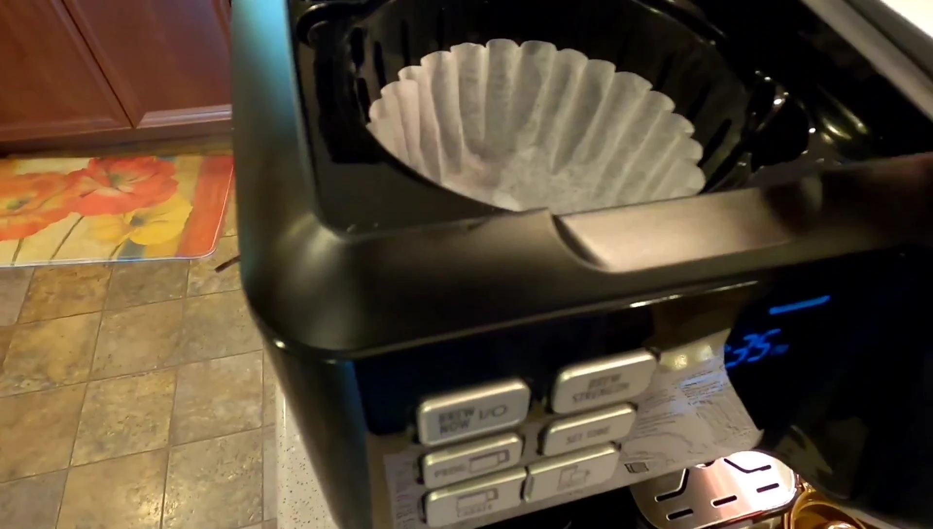 Adding coffee grounds and water to the coffee maker.